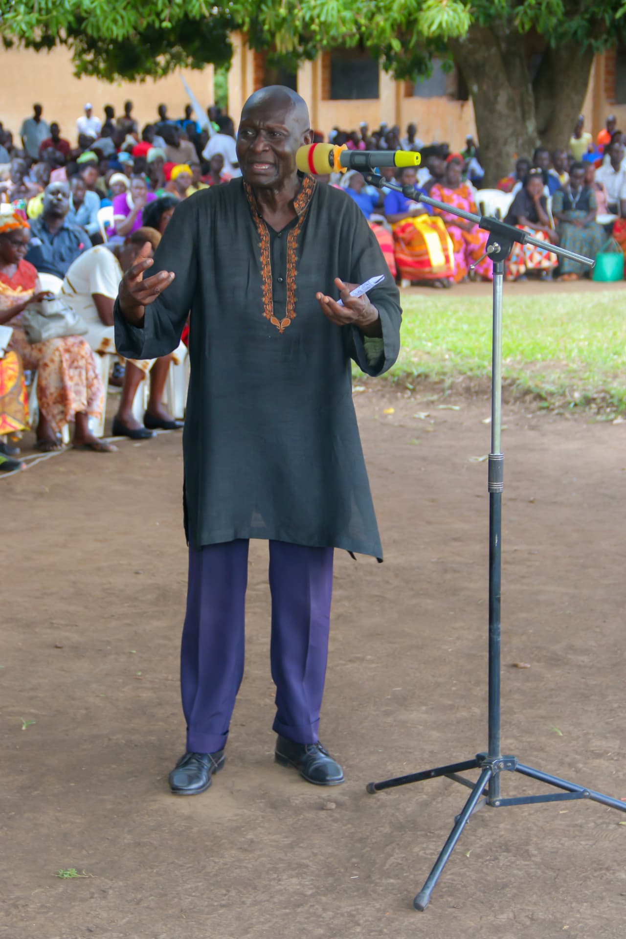 Olara Otunnu speaking at an outdoor community meeting